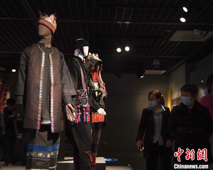 图为：参观者被展出的哈尼族服饰吸引。 王刚 摄